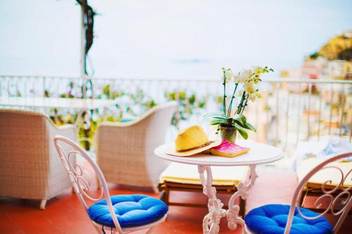 a table with a hat and a vase with flowers on it at Villa Fiorentino in Positano
