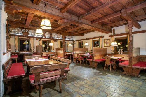 a restaurant with tables and chairs and wooden ceilings at Camping Inntal in Wiesing