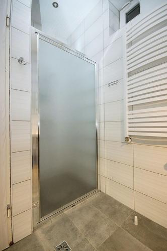 a shower stall with a glass door in a bathroom at Noclegi PODZAMCZE PTTK in Przemyśl