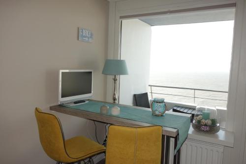 Zimmer mit einem Schreibtisch, einem Computer und Stühlen in der Unterkunft Sylt-Traum Meerblick in Westerland