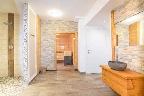 a bathroom with a stone wall and a sink at Camping Inntal in Wiesing