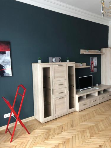 - un salon avec une armoire blanche et une chaise rouge dans l'établissement Freddies apartment, à Kiev
