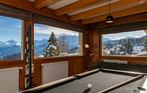 a pool table in a room with windows at Chalet-Hôtel Les Rhodos in Cordon