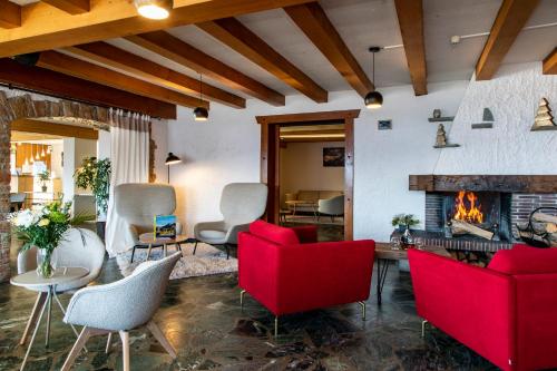 a living room with red chairs and a fireplace at Chalet Les Rhodos in Cordon