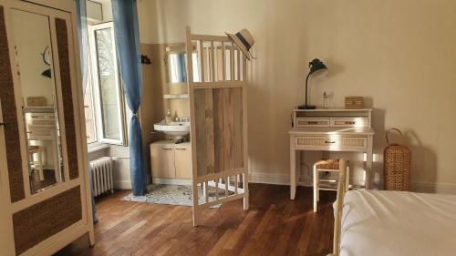 a bedroom with a sink and a desk with a mirror at Cosy Er Lann Gîte Séquoïa in Val Couesnon