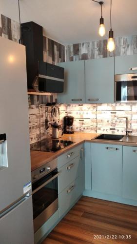 une cuisine avec des armoires blanches et un four à plaques de cuisson dans l'établissement Appartement cosy les pieds dans l’eau, vue mer exceptionnelle, à Crozon