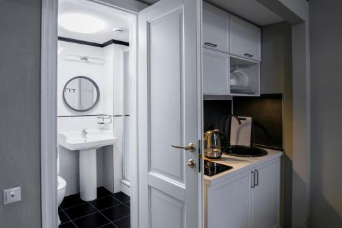 a small kitchen with a sink and a white door at Design Hotel Oscar in Moscow