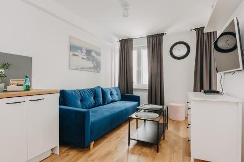 a living room with a blue couch and a table at ShortStayPoland Pańska in Warsaw