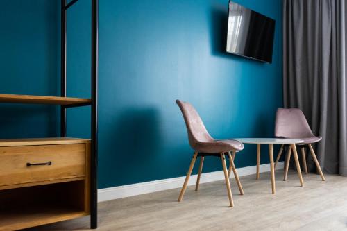 a table and two chairs next to a blue wall at English House in Bistriţa