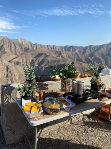 a picnic table with food on top of a mountain at قرية الحمرا راس الخيمة in Ras al Khaimah