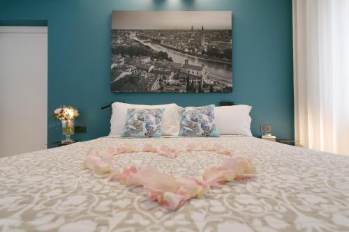 a bed with a heart made out of pink feathers at Hotel Giulietta e Romeo ***S in Verona