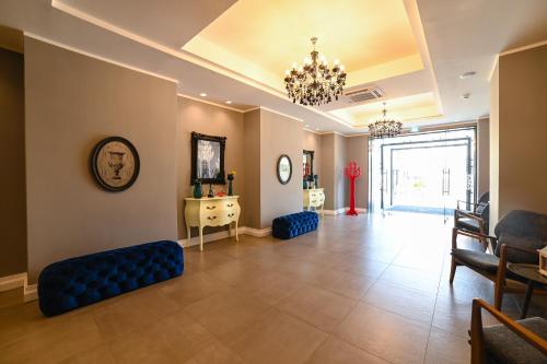 una gran sala de estar con un sofá azul y sillas en Hotel Sogaris, en Paestum