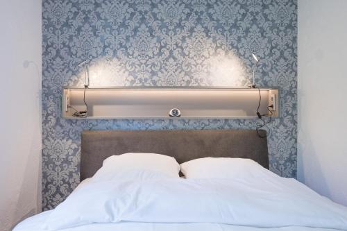 uma cabeceira de cama com papel de parede azul e branco em Ferienhaus Rügenblick em Stahlbrode