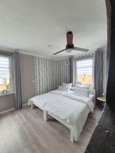 a bedroom with a white bed and a ceiling fan at Haus Kabelitz in Kabelitz