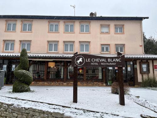 a sign in the snow in front of a building at Le Cheval Blanc - Lac du Der - Logis Hotel in Giffaumont
