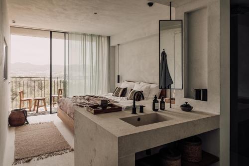 a bedroom with a sink and a bed with a view at OKU Ibiza in San Antonio