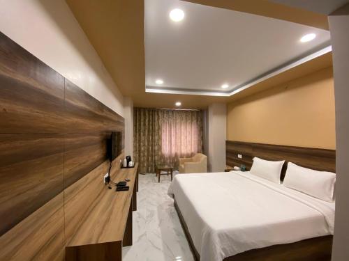 Habitación de hotel con cama y silla en Hotel Laxmi Vilas Palace, en Hājīpur