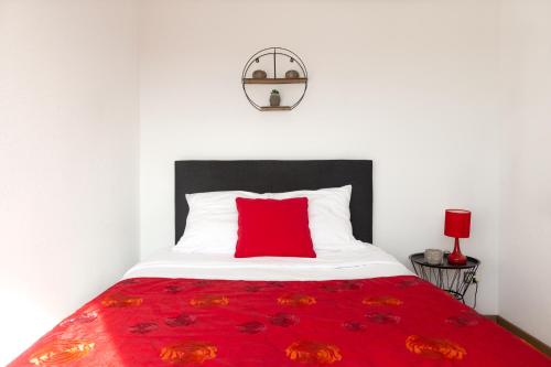 ミュルーズにあるTravel Homes - Le Rebberg, Superbe vue à Mulhouseの赤い毛布付きベッドの上に枕