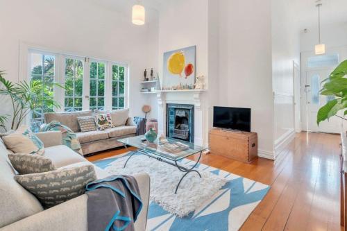 a living room with a couch and a fireplace at Classic Villa Retreat - Steps To Ponsonby Rd in Auckland