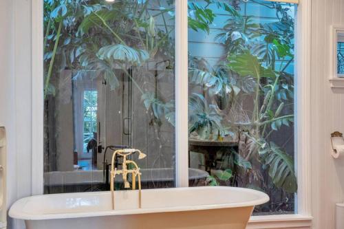 a bathroom with a bath tub with a plant mural at Classic Villa Retreat - Steps To Ponsonby Rd in Auckland