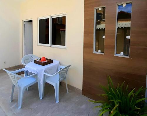 une table blanche avec des chaises et une boîte de tissus dans l'établissement Casa Completa 01 com AR - Encantos de Arraial, à Arraial do Cabo