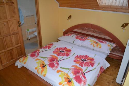 a bedroom with a bed with flowers on it at Ubytovanie Marta Kováčová in Bešeňová