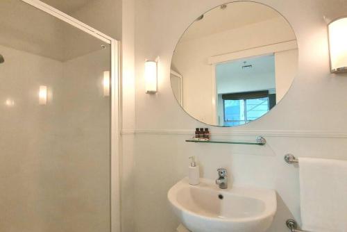 a bathroom with a sink and a mirror at Central and Minimal 1BR I WiFi and Netflix in Auckland
