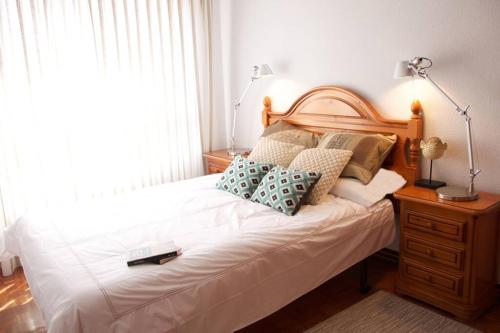 a bedroom with a white bed with pillows on it at Piso en Lekeitio, Costa Vasca, Bizkaia. in Lekeitio
