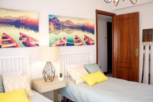 1 dormitorio con 1 cama y una pintura de barcos en Piso en Lekeitio, Costa Vasca, Bizkaia., en Lekeitio