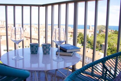a table with two wine glasses on a balcony at Piso en Lekeitio, Costa Vasca, Bizkaia. in Lekeitio