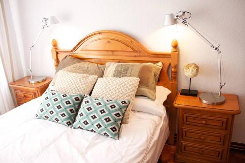 a bed with two lamps and pillows on it at Piso en Lekeitio, Costa Vasca, Bizkaia. in Lekeitio
