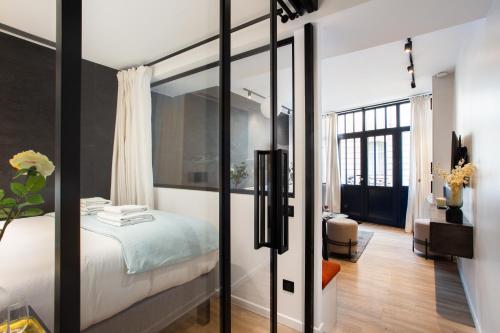 a bedroom with a bed with a glass door at CMG Jacques /Pantheon in Paris