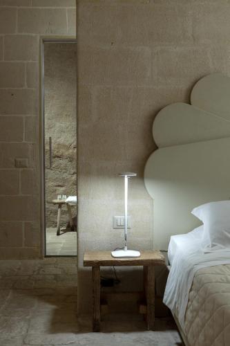 a bedroom with a bed and a table and a mirror at Le Dimore Dell' Idris in Matera