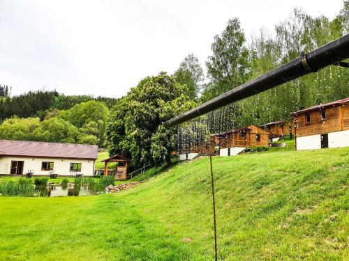 a fence in a field with houses in the background at Letovisko Chobot - village resort in Kácov