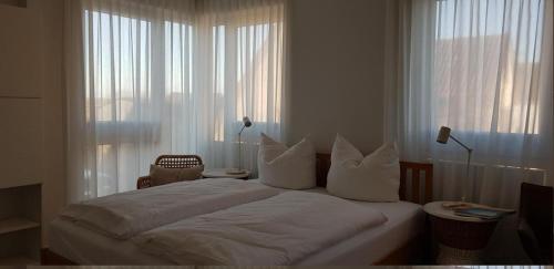 a bedroom with a bed with white sheets and pillows at Haus Achtern Diek in erster Reihe am Meer in Fehmarn