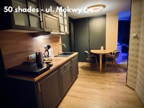 a kitchen with a sink and a table in a room at Sopot Spa Apartament in Sopot