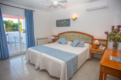 a bedroom with a bed and a table and a window at Hotel Martorell in Colònia de Sant Jordi