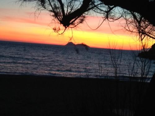 a sunset on the beach with the ocean at Fantastic Matala 1 in Matala
