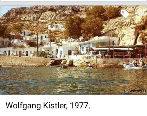 a picture of a body of water with houses on a mountain at Fantastic Matala 1 in Matala