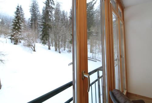 a room with a window looking out at a snow covered yard at Bad Kleinkirchheim RMG family apartments in Bad Kleinkirchheim