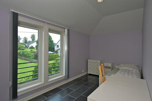 a bedroom with a bed and two windows with a view at Apart Hotel in Gjøvik