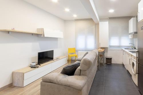 a living room with a couch and a kitchen at Bilbao City Hall V by Aston Rentals in Bilbao