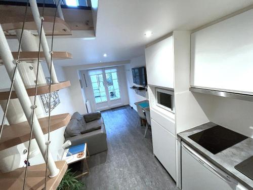 un petit salon avec un canapé et une cuisine dans l'établissement L'IDEAL 9 (hypercentre avec terrasse), à Deauville