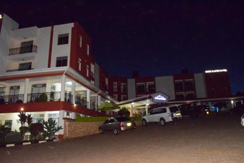 a parking lot in front of a building at night at Meru Slopes Hotel in Meru