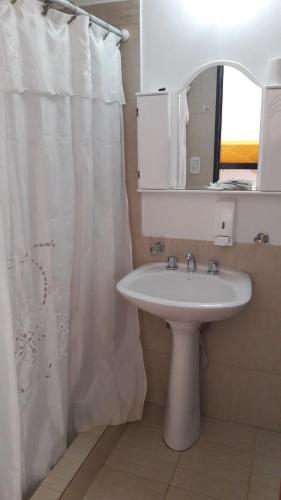 a bathroom with a sink and a shower curtain at Complejo Brisas Místicas in Las Grutas