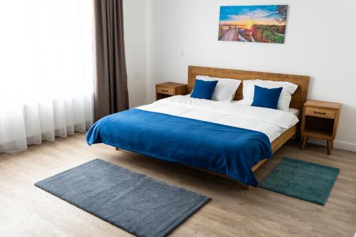 a bedroom with a large bed with blue sheets and pillows at English House in Bistriţa