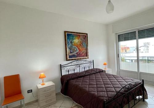 a bedroom with a bed and a painting on the wall at HOME SALENTO in Taviano