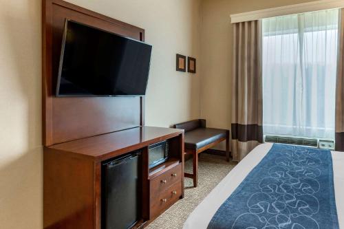 a hotel room with a bed and a flat screen tv at Comfort Suites Manassas Battlefield Park in Manassas