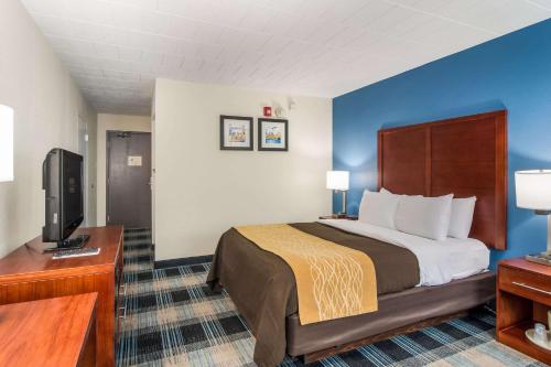 a hotel room with a bed and a flat screen tv at Comfort Inn & Suites Pittsburgh Fox Chapel in Montrose Hill