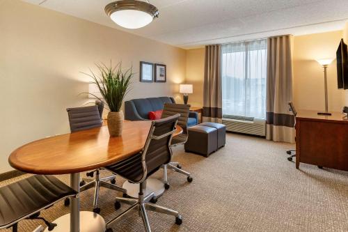 a hotel room with a table and chairs and a desk at Comfort Suites Manassas Battlefield Park in Manassas